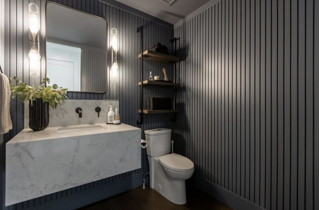 A bathroom with a dark painted feature wall