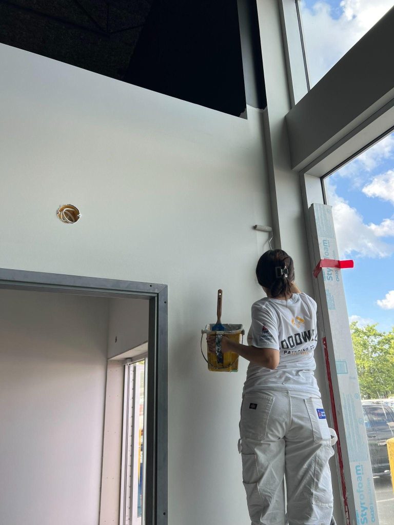 A Goodwell painter cutting in around a window on an interior repaint